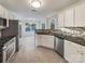 Well-lit kitchen featuring white cabinets, stainless steel appliances, and sleek black countertops at 12308 Ridge Cove Cir, Charlotte, NC 28273