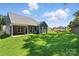Spacious backyard with green grass surrounding the new construction home, complete with a covered patio at 149 Prestwick Way # 39, Mooresville, NC 28115