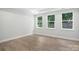 Bright, spacious bedroom with three windows showcasing an outdoor view and hardwood flooring at 149 Prestwick Way # 39, Mooresville, NC 28115