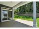 Covered patio area with sliding glass door overlooking a backyard area with lush landscaping and a retaining wall at 149 Prestwick Way # 39, Mooresville, NC 28115