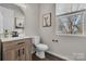 Charming powder room with wood vanity, framed art and natural light from large window at 16764 Summers Walk Blvd, Davidson, NC 28036