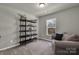 Neutral guest bedroom with comfortable seating and shelving for storage at 16764 Summers Walk Blvd, Davidson, NC 28036