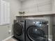 Efficient laundry room equipped with gray front-load washer and dryer set and shelving at 16764 Summers Walk Blvd, Davidson, NC 28036