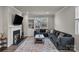 Living room showcasing a cozy fireplace, a large sectional couch, and natural light at 16764 Summers Walk Blvd, Davidson, NC 28036