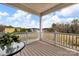 Cozy porch with wooden floor, overlooking a field with neighboring colorful houses and blue skies at 16764 Summers Walk Blvd, Davidson, NC 28036