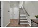 Inviting foyer with beautiful hardwood floors and a classic staircase featuring a wooden handrail at 16764 Summers Walk Blvd, Davidson, NC 28036