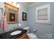 Powder room with a decorative mirror, wooden vanity, and soft blue walls at 2622 Oakhurst Dr # 23, Rock Hill, SC 29730