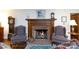 Living room featuring a cozy fireplace with a wooden mantel and hearth, flanked by two comfortable armchairs at 2622 Oakhurst Dr # 23, Rock Hill, SC 29730
