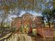 Brick home backyard showcasing a round turret, deck, patio, and lush greenery at 2683 Beulah Church Rd, Matthews, NC 28104