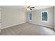 Comfortable bedroom featuring neutral carpeting, two bright windows, and a ceiling fan at 2683 Beulah Church Rd, Matthews, NC 28104