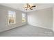 Bright bedroom features neutral carpeting, two bright windows, and a ceiling fan at 2683 Beulah Church Rd, Matthews, NC 28104