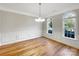 Elegant dining room featuring wood floors, paneled walls, and natural light from arched windows at 2683 Beulah Church Rd, Matthews, NC 28104