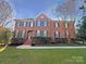 Stately brick home with symmetrical design, black shutters, landscaped yard, and a welcoming front entrance at 2683 Beulah Church Rd, Matthews, NC 28104