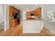 Well-lit kitchen featuring wood cabinets, black appliances, a breakfast bar, and hardwood floors at 2683 Beulah Church Rd, Matthews, NC 28104