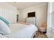 This bedroom has a neutral palette, TV on bureau, chair near the window, and white coverlet at 3193 Burnello Ct, Iron Station, NC 28080