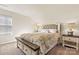 Bright bedroom with a tufted headboard, side tables with lamps, and a window with blinds at 3193 Burnello Ct, Iron Station, NC 28080