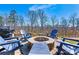 Stone fire pit surrounded by blue Adirondack chairs, set on a brick patio, ideal for backyard gatherings at 3193 Burnello Ct, Iron Station, NC 28080