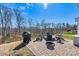 Outdoor patio with a stone fire pit, grill, and Adirondack chairs, perfect for backyard entertaining and relaxing at 3193 Burnello Ct, Iron Station, NC 28080