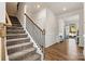 Open foyer showcasing wood flooring, classic wainscoting and a stairway to the second floor at 3193 Burnello Ct, Iron Station, NC 28080
