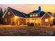 Exterior of the house at dusk highlighting the spacious backyard, back porch, and patio with outdoor grill at 4421 Windwood Cir, Charlotte, NC 28226
