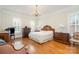 Large main bedroom with hardwood floors, decorative chandelier, and plantation shutters at 4421 Windwood Cir, Charlotte, NC 28226