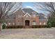 Beautiful two-story brick home with mature trees, lush shrubbery and a manicured lawn at 4421 Windwood Cir, Charlotte, NC 28226
