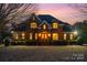 Charming brick home with meticulous landscaping, featuring a welcoming front entrance with illuminated windows at 4421 Windwood Cir, Charlotte, NC 28226