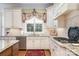 Well-lit kitchen with stainless steel appliances, granite countertops, and a decorative window treatment at 4421 Windwood Cir, Charlotte, NC 28226