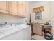 Charming laundry room with plenty of storage cabinets, a utility sink, and a modern washer and dryer set at 4421 Windwood Cir, Charlotte, NC 28226