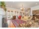 Spacious living room boasting hardwood floors, fireplace, chandelier, and multiple seating areas at 4421 Windwood Cir, Charlotte, NC 28226