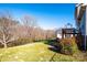 A lush, green backyard featuring a fenced perimeter, a wooden deck, and mature trees at 538 30Th Avenue Ne Cir, Hickory, NC 28601