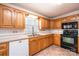 Well-lit kitchen featuring oak cabinets, tile backsplash, and modern black appliances at 538 30Th Avenue Ne Cir, Hickory, NC 28601