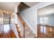 View of a carpeted staircase leading to the upper level, complemented by hardwood floors and a bright living space at 538 30Th Avenue Ne Cir, Hickory, NC 28601