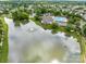 Aerial view showcasing the community lake with a fountain, clubhouse, and pool area at 561 Keystone Nw Ct, Concord, NC 28027