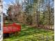 Backyard features a red deck, a green lawn, and tree line at 561 Keystone Nw Ct, Concord, NC 28027