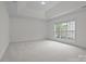 Large primary bedroom with tray ceiling and big picture window at 561 Keystone Nw Ct, Concord, NC 28027