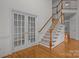 Elegant foyer featuring hardwood floors, staircase with wooden railing, and glass french doors at 561 Keystone Nw Ct, Concord, NC 28027