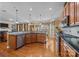 Modern kitchen with dark countertops, wood cabinetry, stainless steel appliances, and an open design at 561 Keystone Nw Ct, Concord, NC 28027