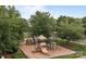 Community playground with mature trees and ample space for children at 561 Keystone Nw Ct, Concord, NC 28027