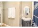 Bathroom with dark blue vanity, white sink and toilet, mirror and towel rack at 642 W Front St, Statesville, NC 28677