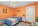 Cozy bedroom with orange walls, ceiling fan, a comfortable bed and a decorative rug at 642 W Front St, Statesville, NC 28677