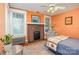 Bedroom with brick fireplace, ceiling fan, natural light, and hardwood flooring at 642 W Front St, Statesville, NC 28677