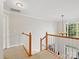 Bright hallway with carpet flooring, natural wood railing, chandelier, and abundant natural light at 821 Lynnwood Farms Dr, Fort Mill, SC 29715