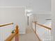 Upstairs hallway showcasing wood railings, neutral paint, and carpeted floors leading to various rooms at 821 Lynnwood Farms Dr, Fort Mill, SC 29715