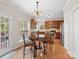 Bright kitchen with wooden cabinets, stainless steel appliances, and an adjacent dining area with a decorative table and chairs at 821 Lynnwood Farms Dr, Fort Mill, SC 29715