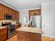 Spacious kitchen featuring stainless steel appliances, an island with stone countertop, and natural wood cabinets at 821 Lynnwood Farms Dr, Fort Mill, SC 29715
