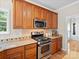 Kitchen features wood cabinets, stainless steel appliances, and light stone countertops with a patterned backsplash at 821 Lynnwood Farms Dr, Fort Mill, SC 29715