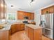 Well-lit kitchen featuring wood cabinets, granite countertops, stainless steel appliances, and a functional kitchen island at 821 Lynnwood Farms Dr, Fort Mill, SC 29715