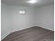 A clean, simple room with gray wood-look flooring, white walls and minimal furnishings, a small window for natural light at 927 Locke St, Salisbury, NC 28144