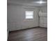 Bedroom with a painted brick wall and a window and hardwood floors at 927 Locke St, Salisbury, NC 28144